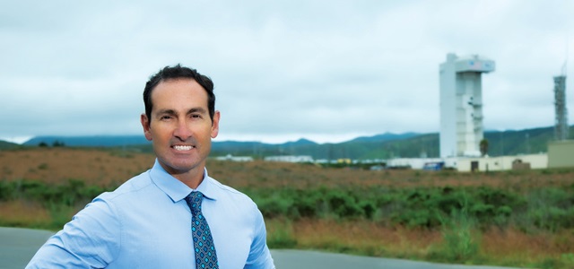 male smiling in front of rocket launch site