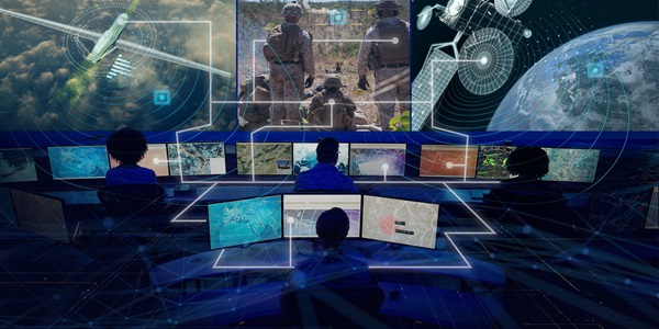 people working in front of large computer monitors