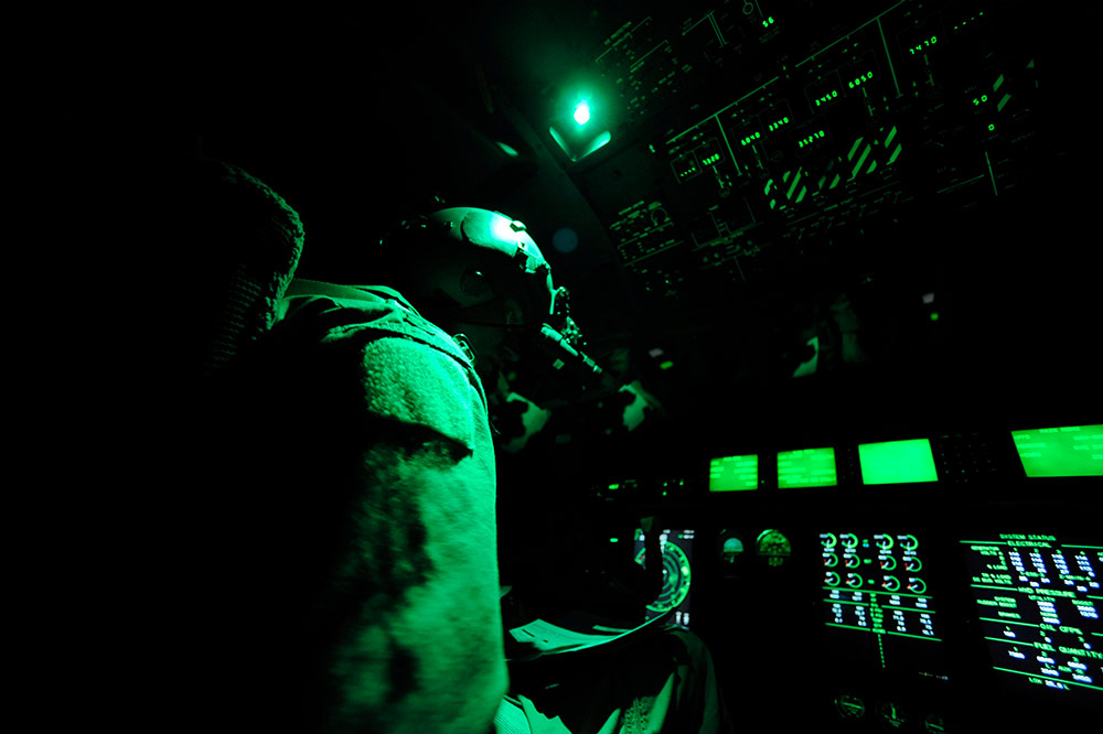 interior of C-130J showing airman monitoring aircraft systems