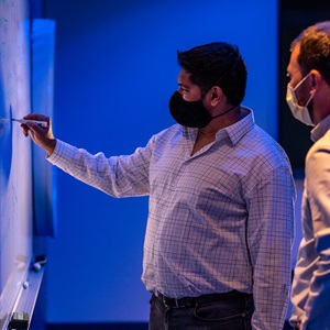 Disruptive Concepts and Technologies: Quantum Technology Man writing on whiteboard