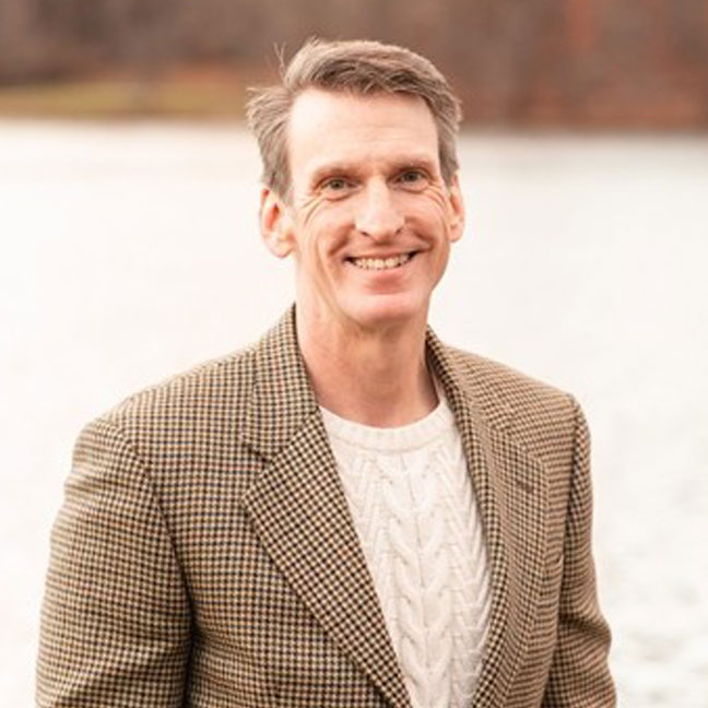 headshot of man wearing suit jacket