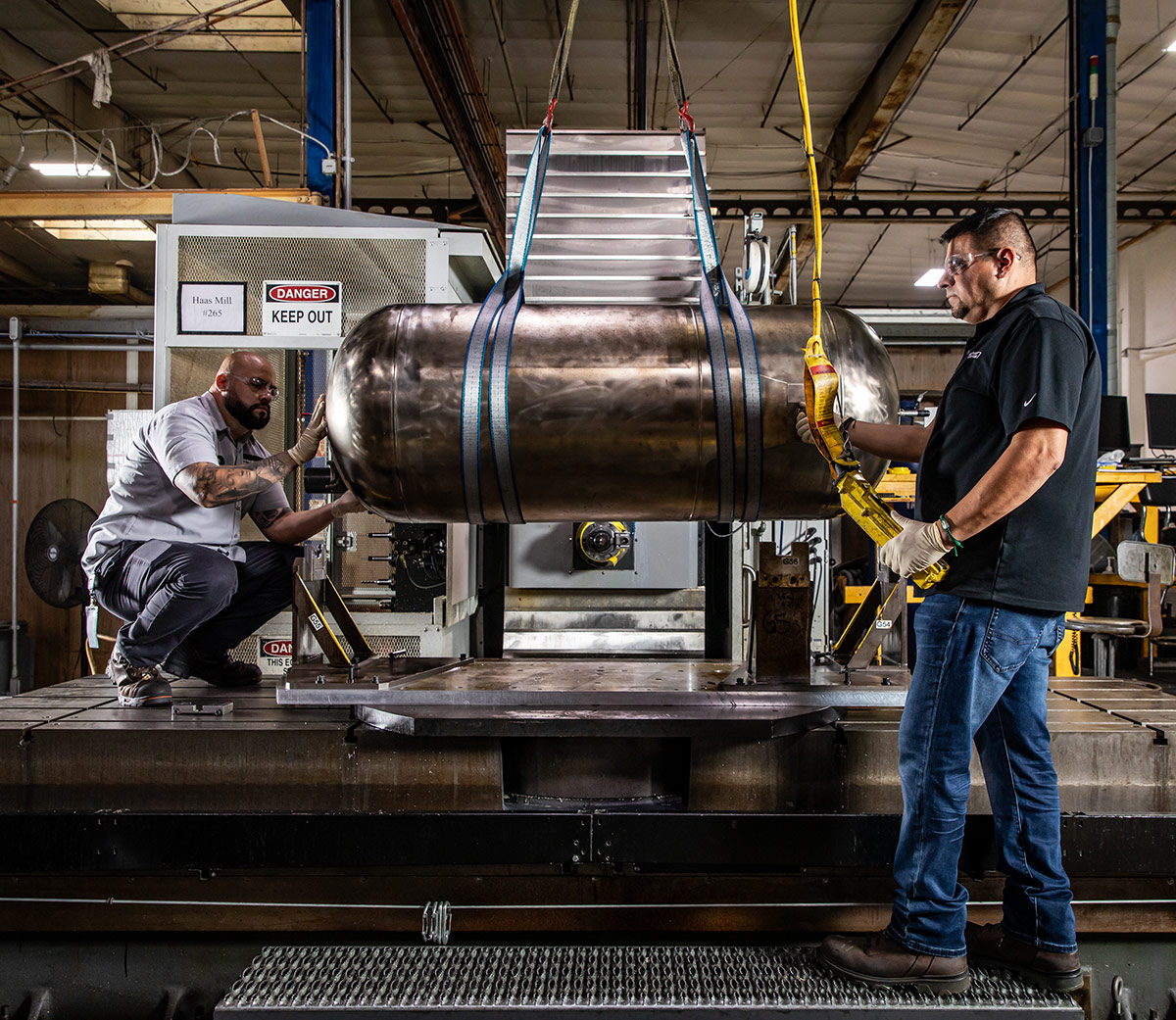two men working on a propulsion tank