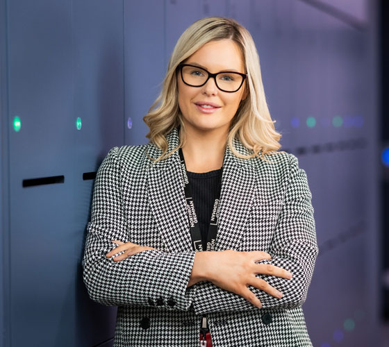 Photo of woman glasses with folded arms smiling. 