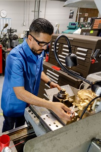 Melvin Aguirre working on equipment in the manufacturing internship program.