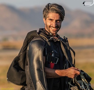 Kia Ravanfar smiles with mountains in the background.
