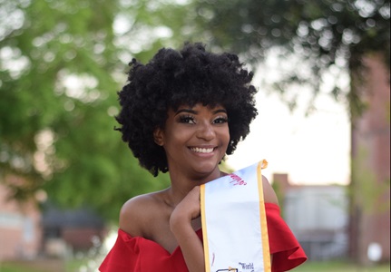 College graduate holding sash