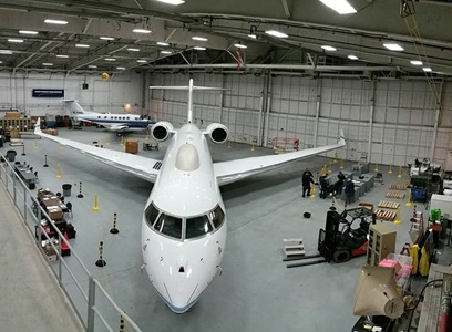Interior of hanger with white jet looking head-on