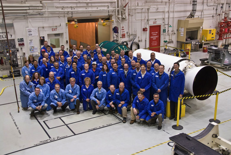 Minuteman Crew people in front of rocket motor in manufacturing facility