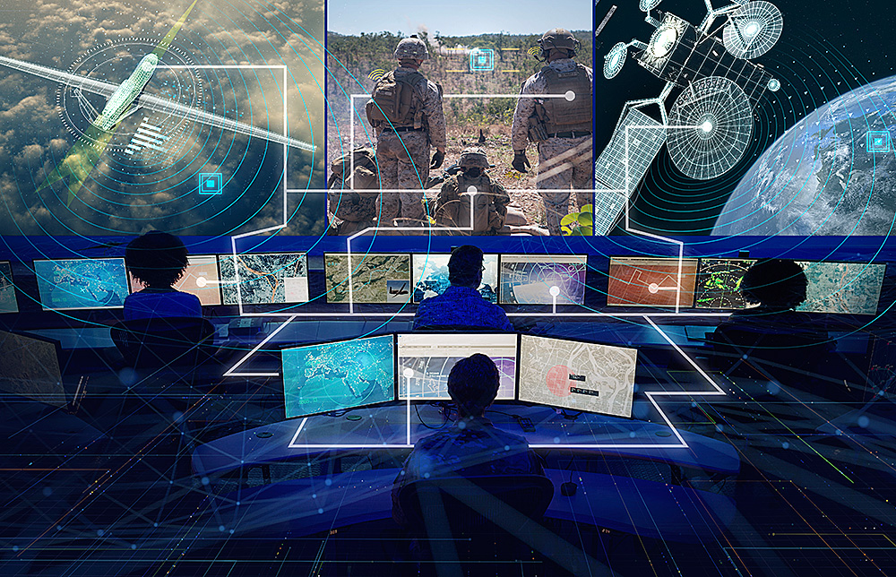 dark room with many techicians computers viewing large screen in foreground