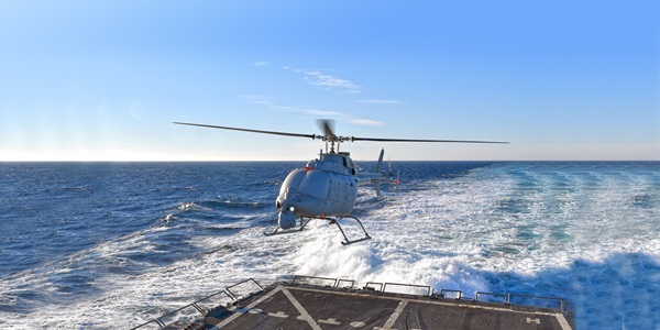 Fire Scout Unmanned helicopter flying above a landing pad in the sea