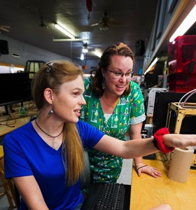 Two Caucasian women speaking at desk