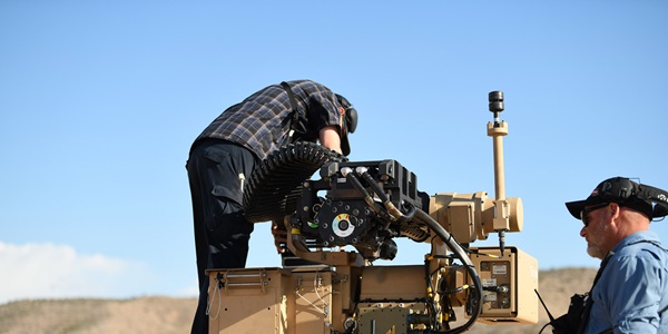 Keeping-Bushmaster-Cannons-Peak-Performance-HERO two males working on a large gun