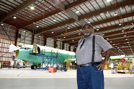 Lake Charles Sustaintment and Modernization man standing in front of an airplane inside of an airplane hangar