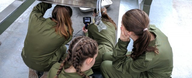 Three female STAAR students repairing an aircraft engine