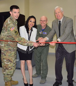 four people cutting a red ribbon