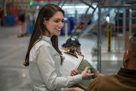 Young Woman holding clipboard and smilin in facility