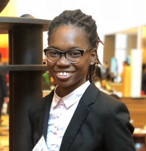 female wearing glasses and black jacket smiling 