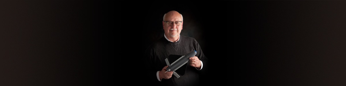 Unfinished-Business-Hero male holding a model of a munition