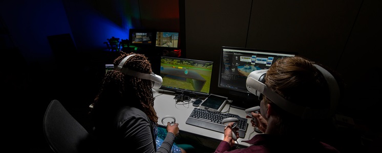 ar-vr-formulas-for-success-hero Two people sit at computers wearing virtual reality headsets