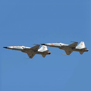 F-5 tile 2 fighter jets inflight against blue sky