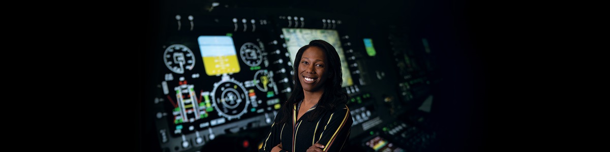 black woman smiling in front of computer monitors