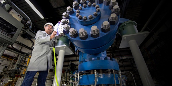 Hypersonic Testing – home page man standing in front of giant blue machine