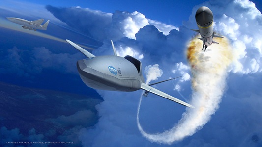 Interoperability Leads to LongShot An aircraft flies through clouds next to a missile with smoke trail behind it.