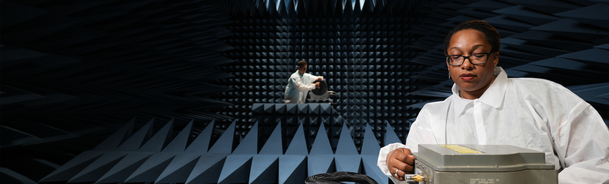 Sound room with a women in glasses in forefront and male in background