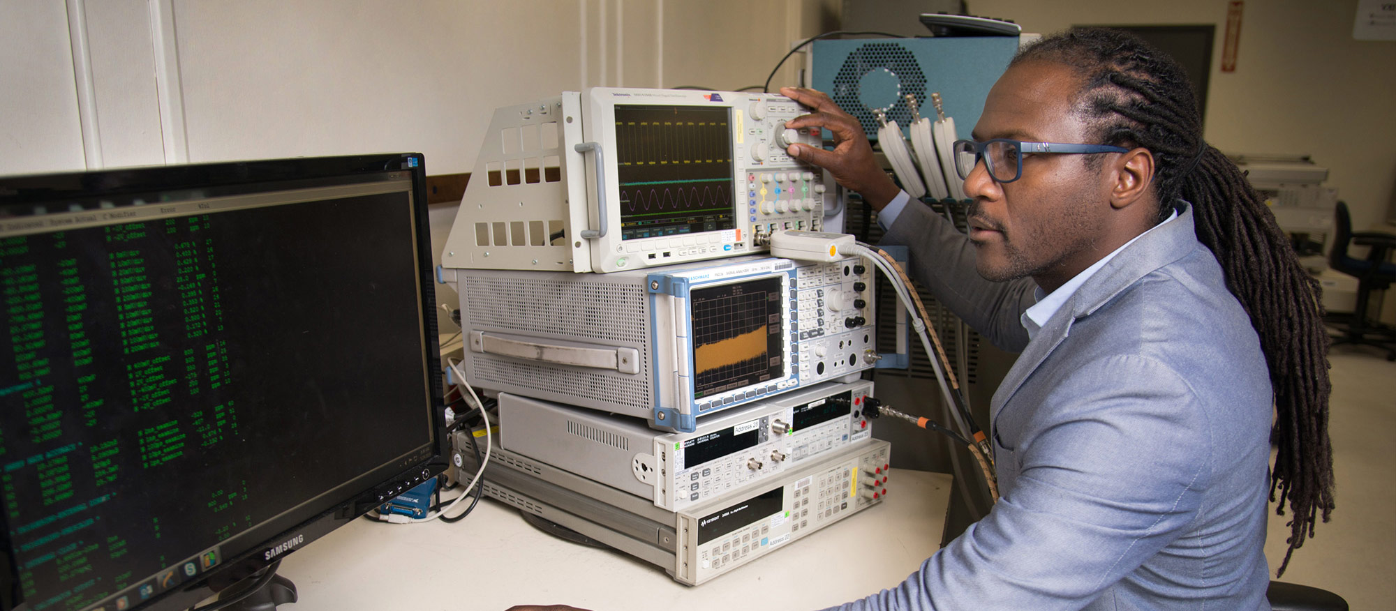 man in lab suit working on computer