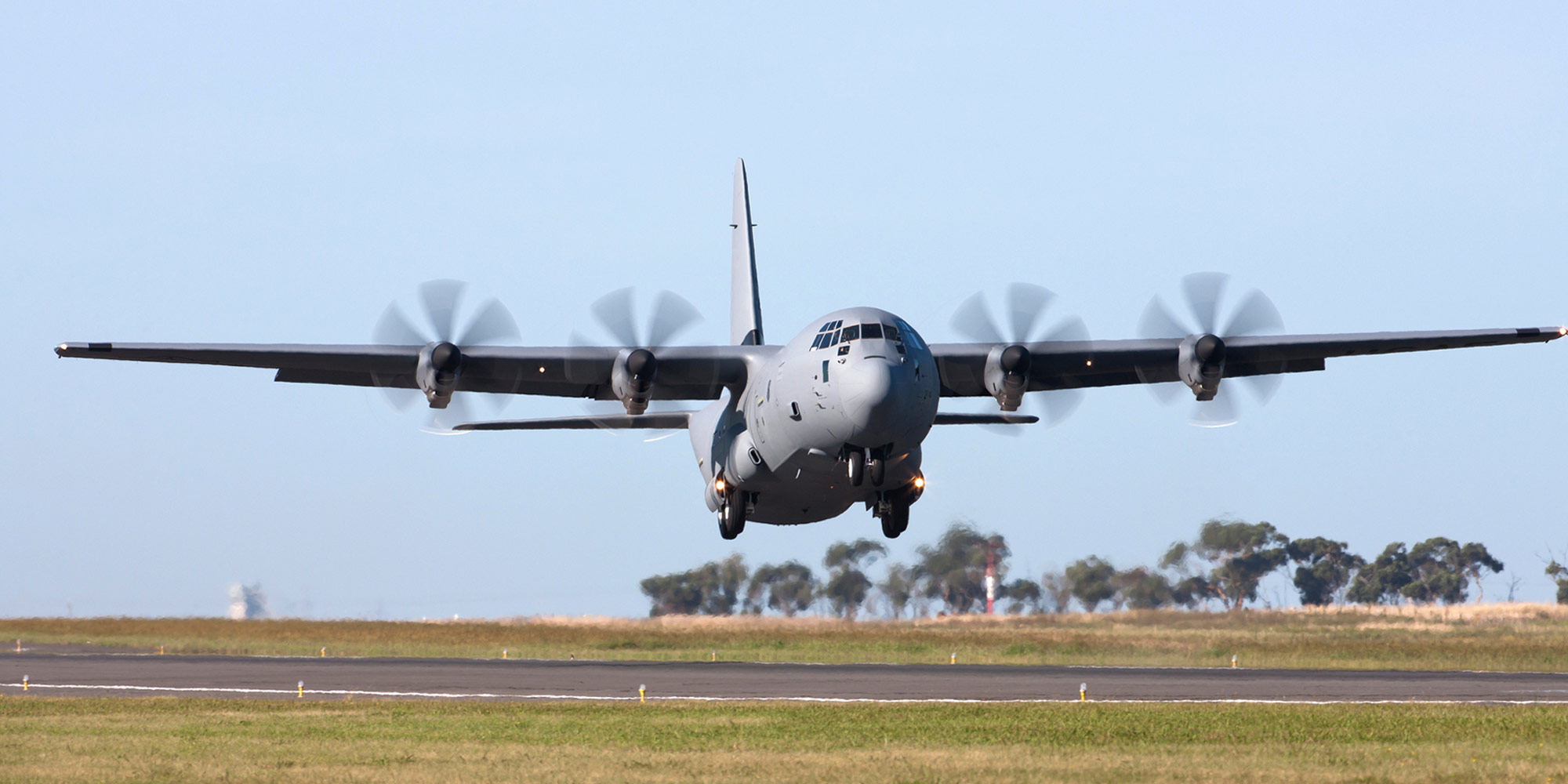 c-130 military transport aircraft taking off from runway