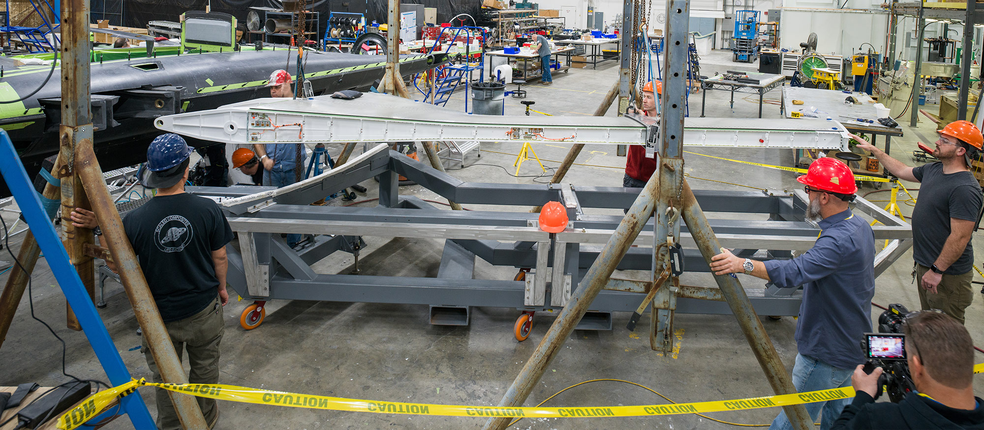 men working on aircraft wings in hangar