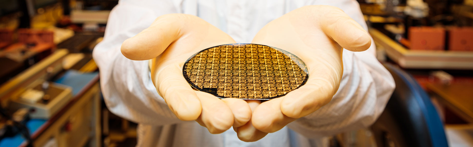 hands holding microelectronics in a lab
