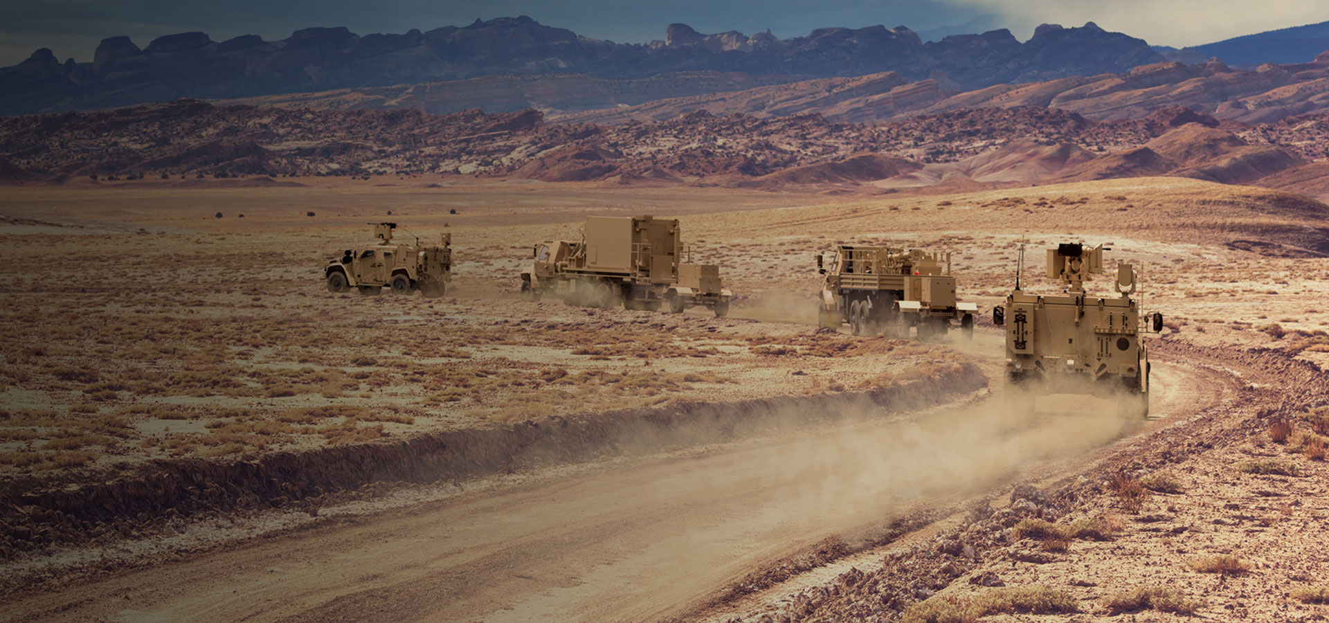 Military vehicles driving across the desert