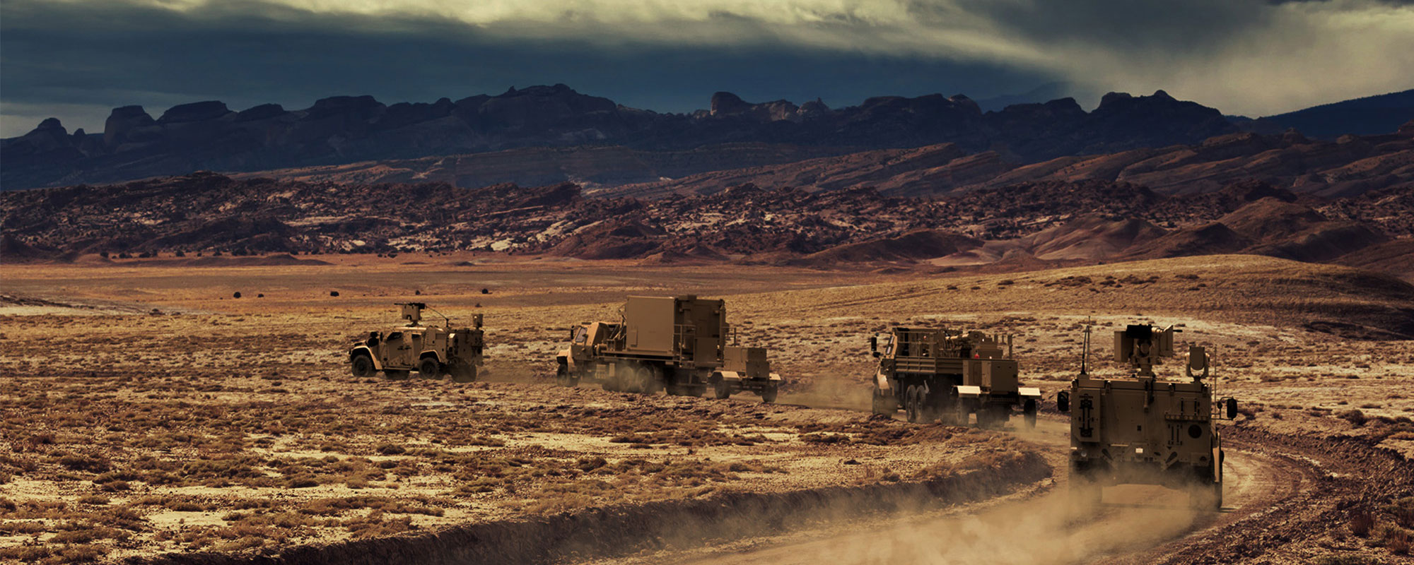 army truck convoy in mountainous desert