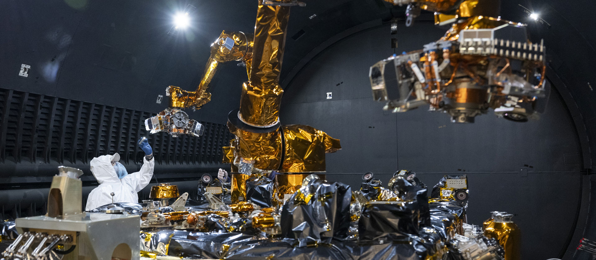 Engineers work on space technology in lab.