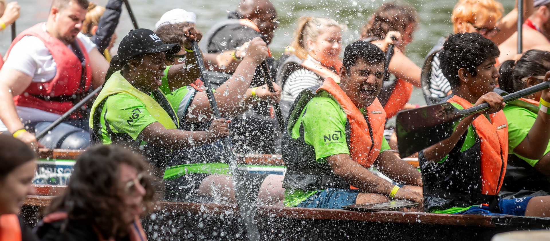 Image of employees in boating race at company event.