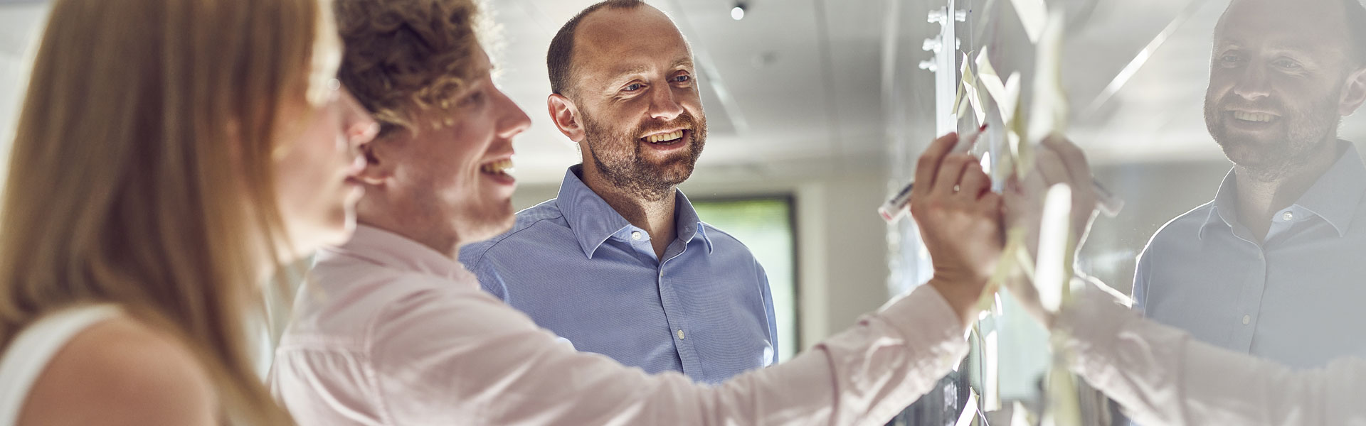 Image of three adults at whiteboard