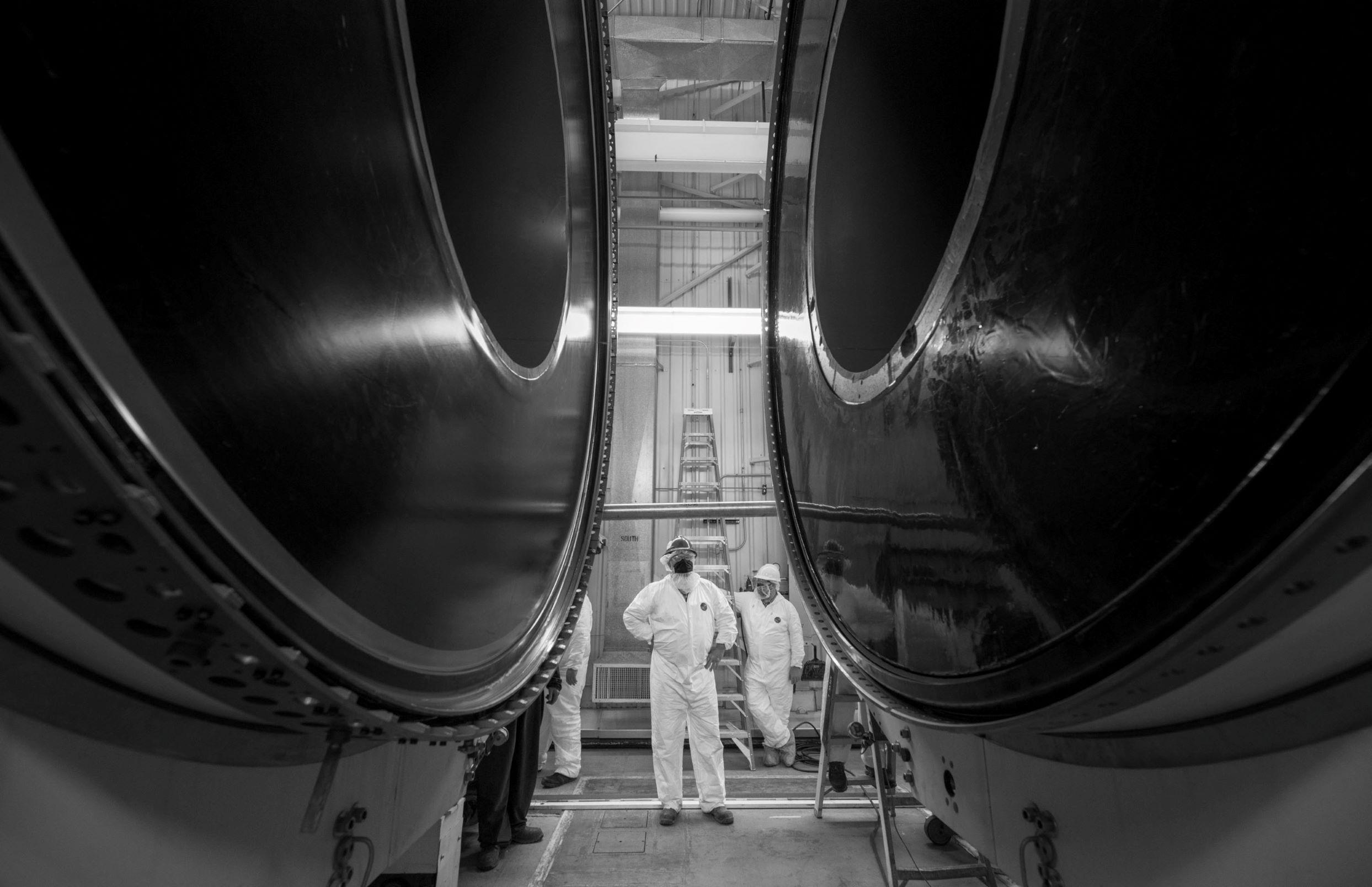 FSB-Two-Segments-SLS A engineer stands in between the center of a rocket motor inside a facility