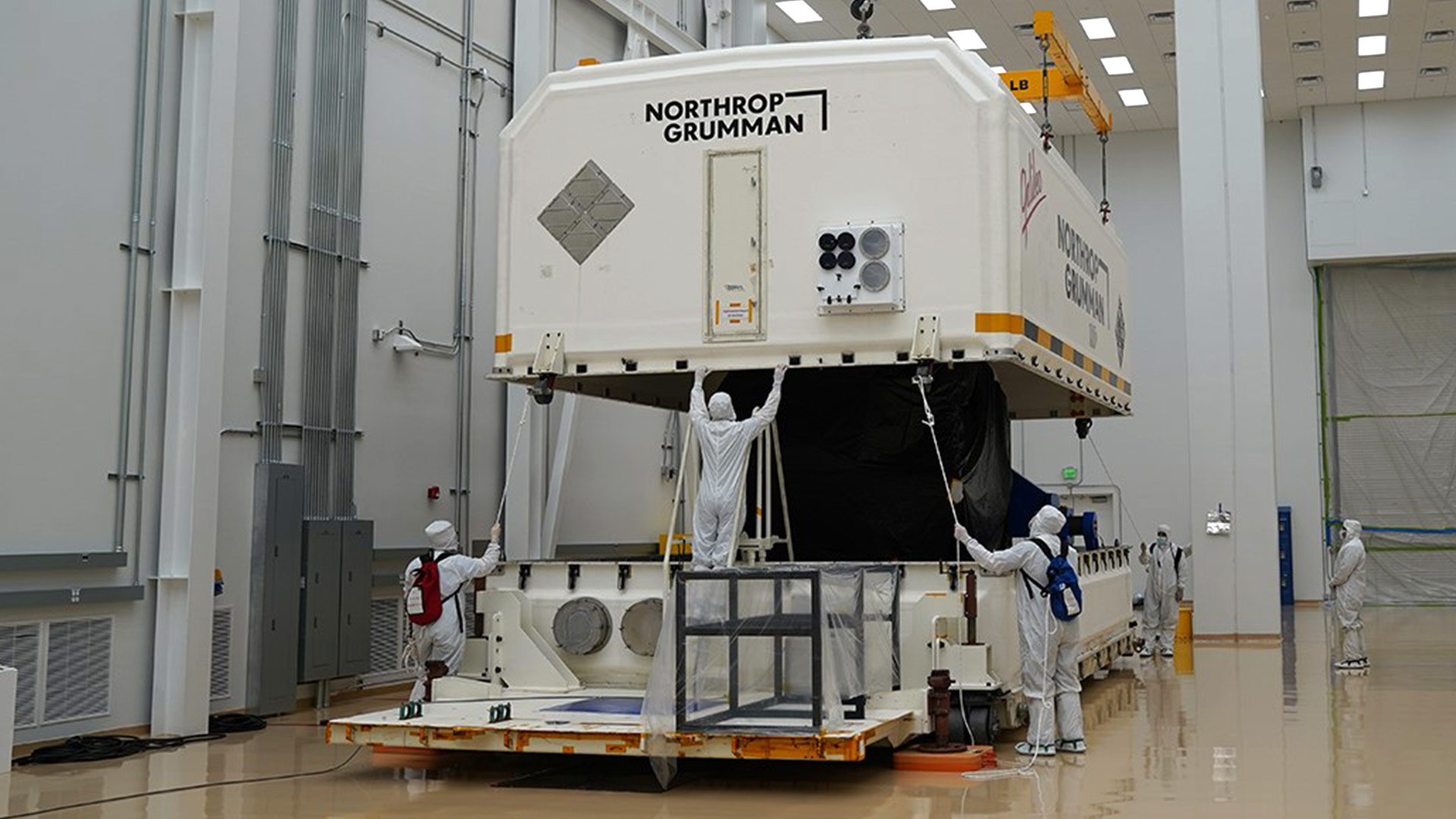 Packaging JPSS-2 for shipment workers packaging spacecraft