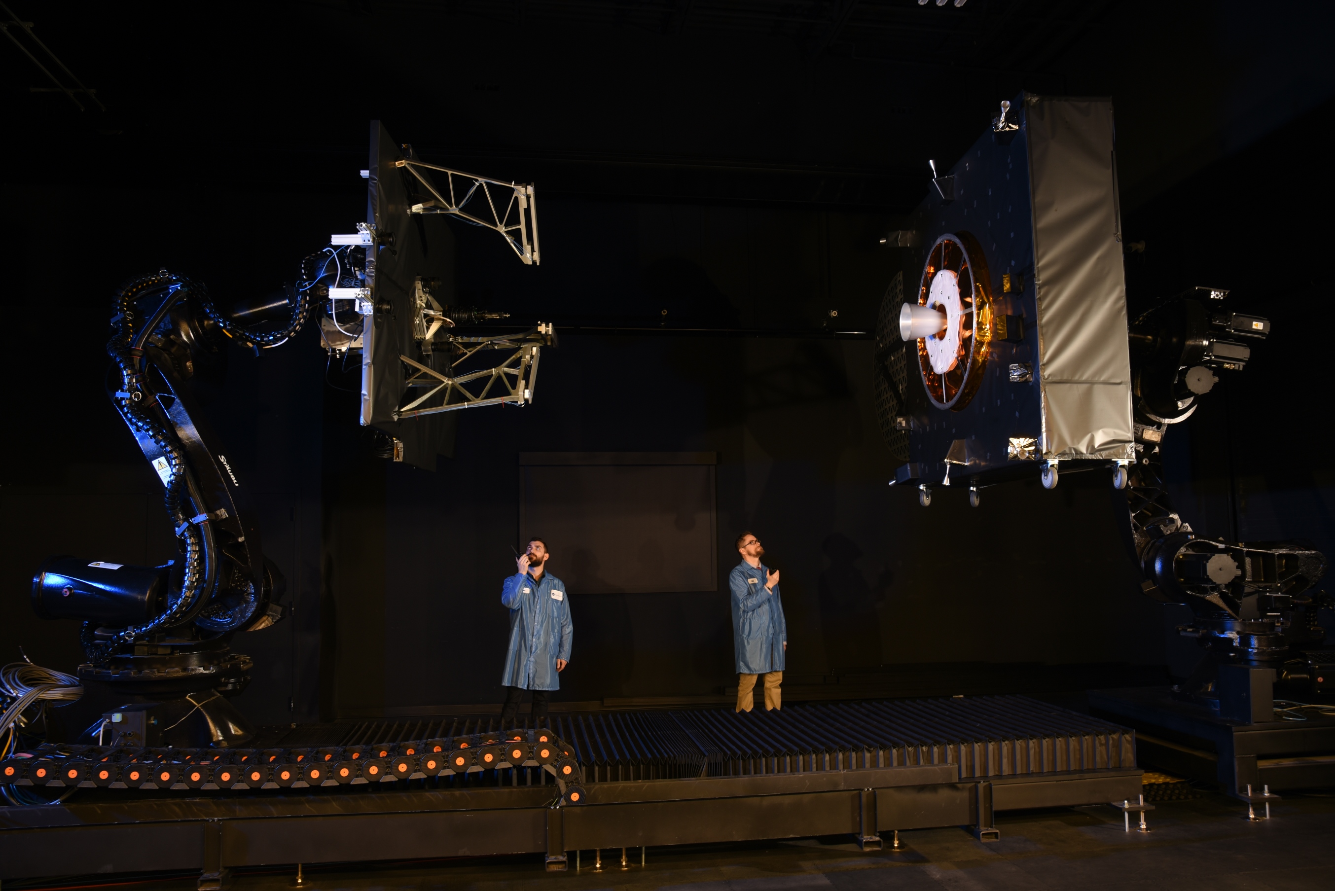 MEV Proximity Operations two technicians in proximity operations lab with model spacecraft