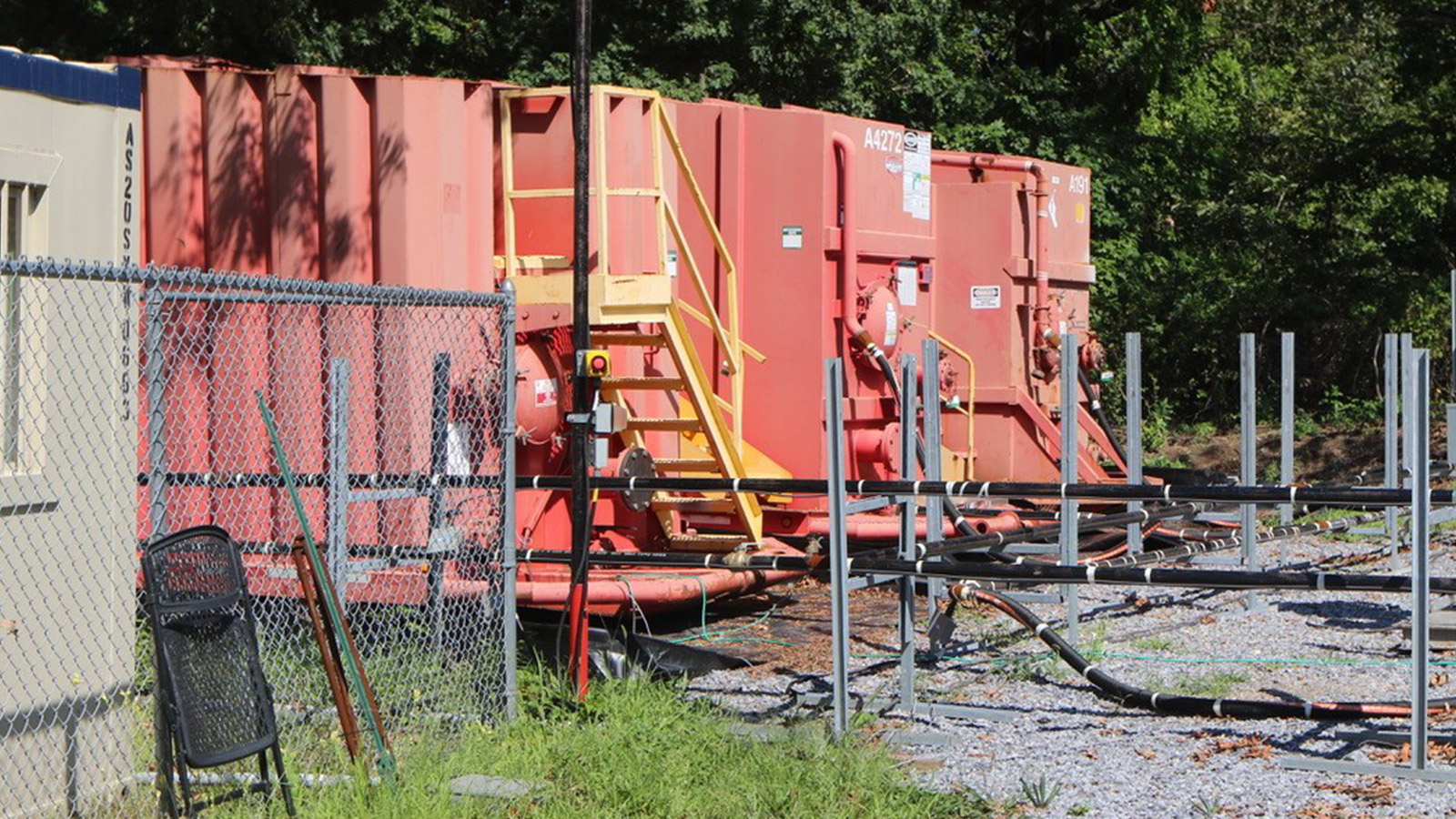 Bethpage Soil Cleanup Work Zone red storage trailers on gravel bed