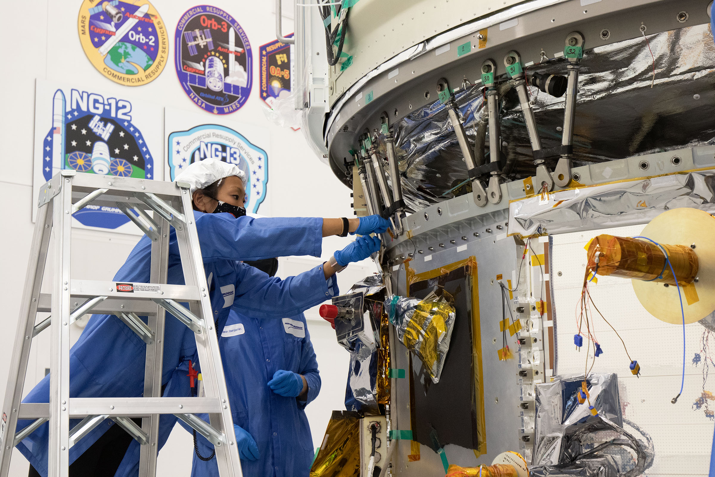 WFF-2020-043-164 Asian engineer on ladder assembles parts to Cygnus Space Craft in Wallops Island flightfacility