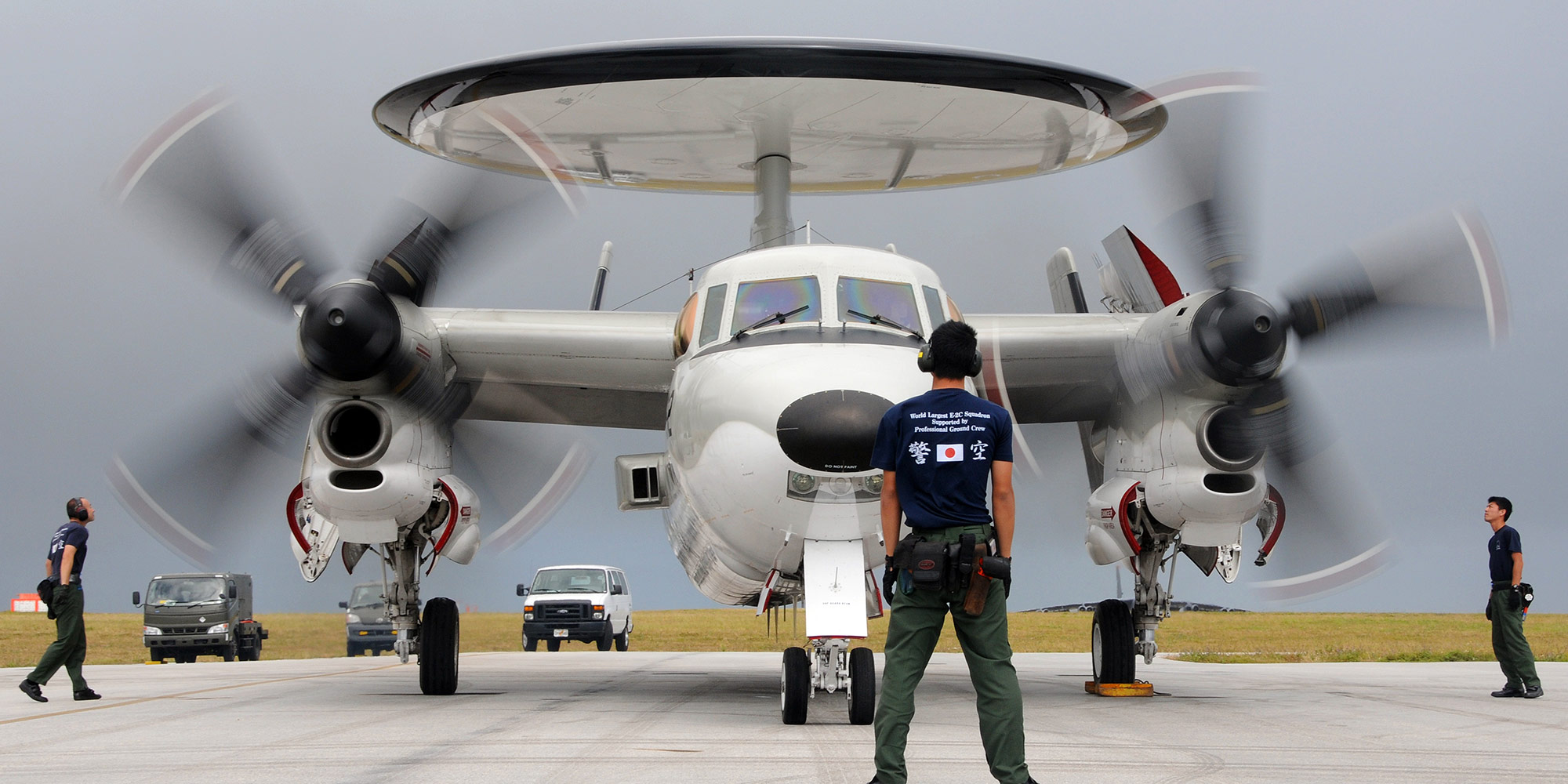 Northrop Grumman in Japan man standing in front of military plane with large propellers